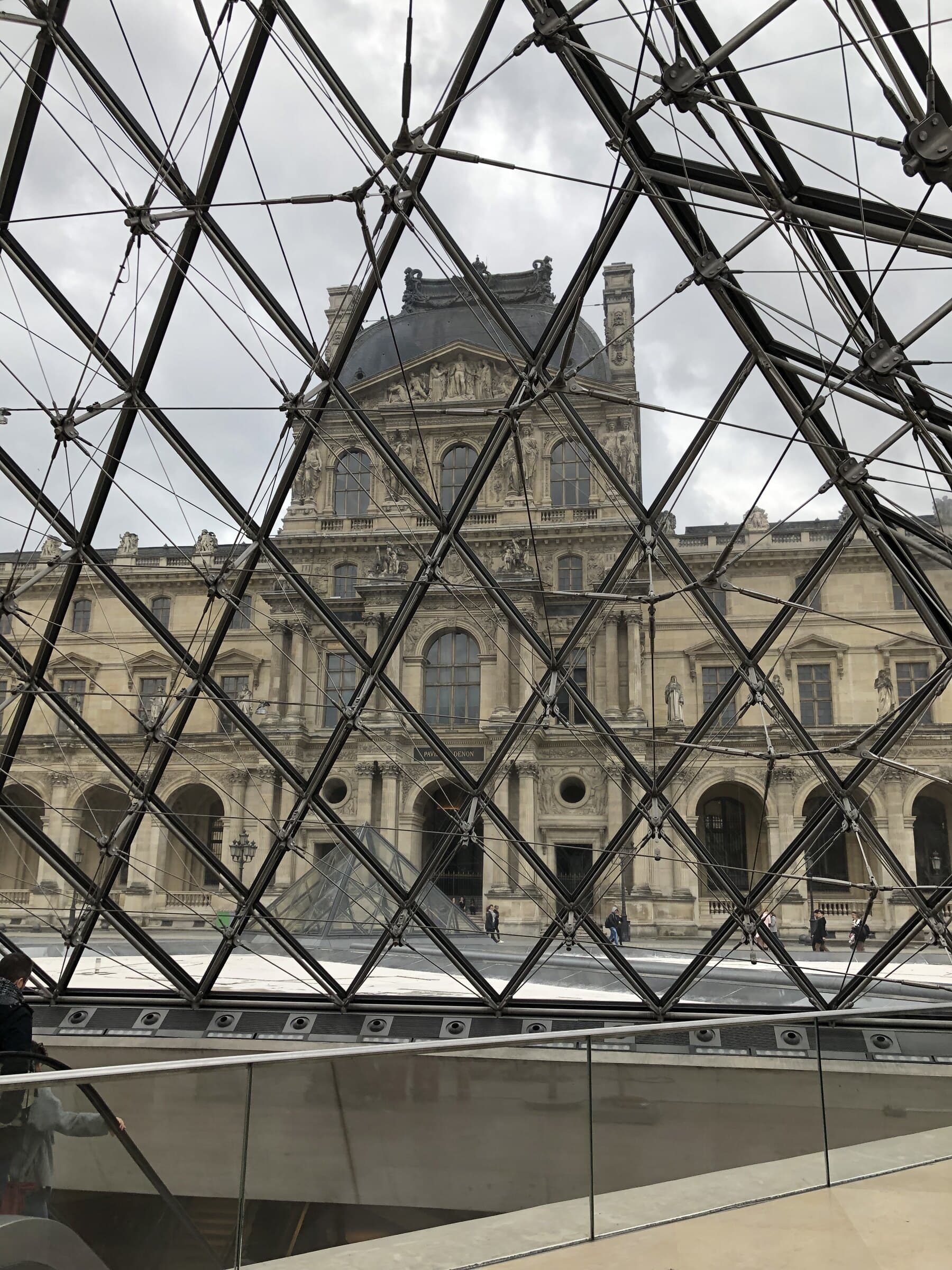 The Louvre pyramid grid lit against a dark Paris sky.