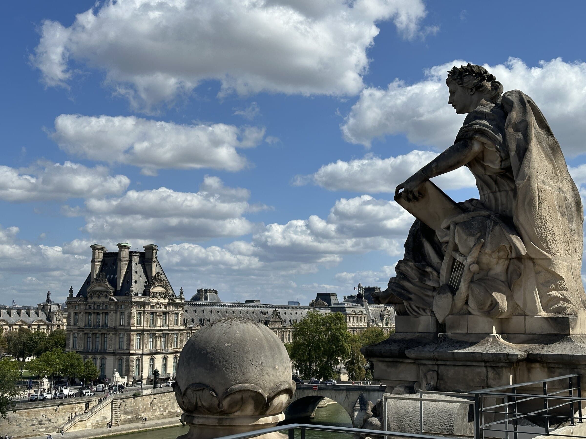 Paris sculpture and skyline beneath an open sky.